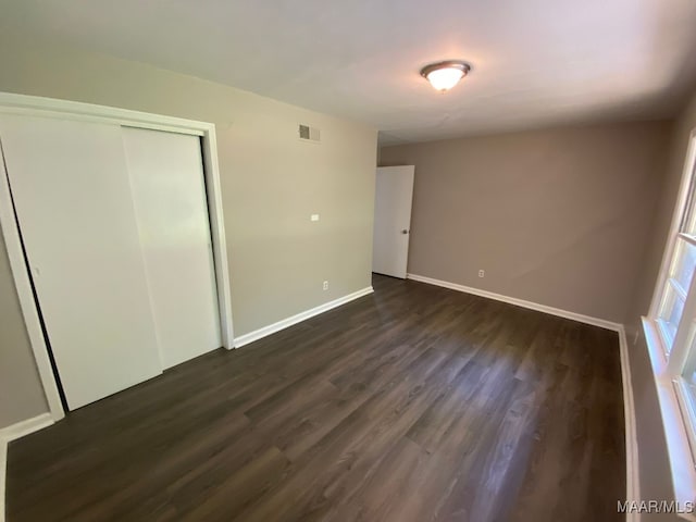 unfurnished bedroom with dark hardwood / wood-style flooring