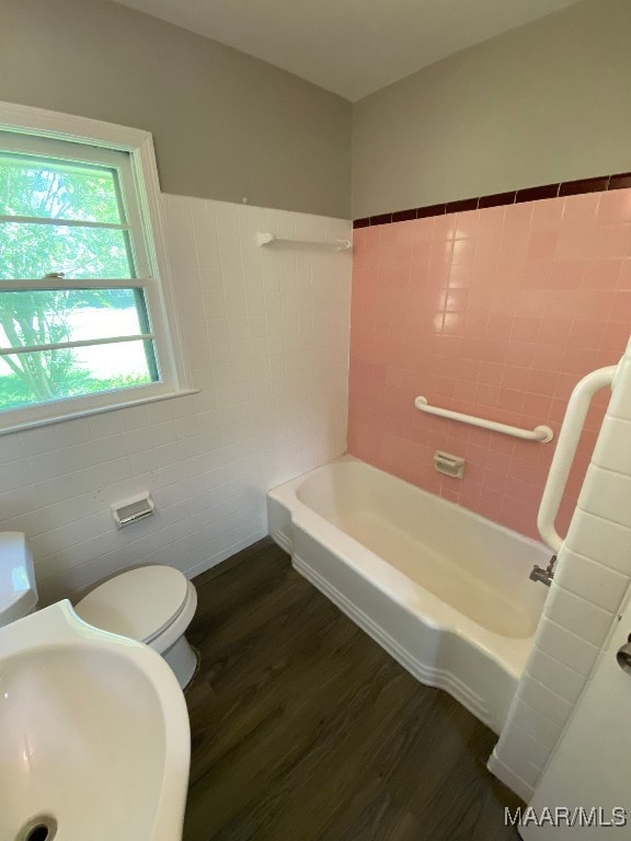 bathroom featuring tile walls, sink, hardwood / wood-style flooring, and toilet