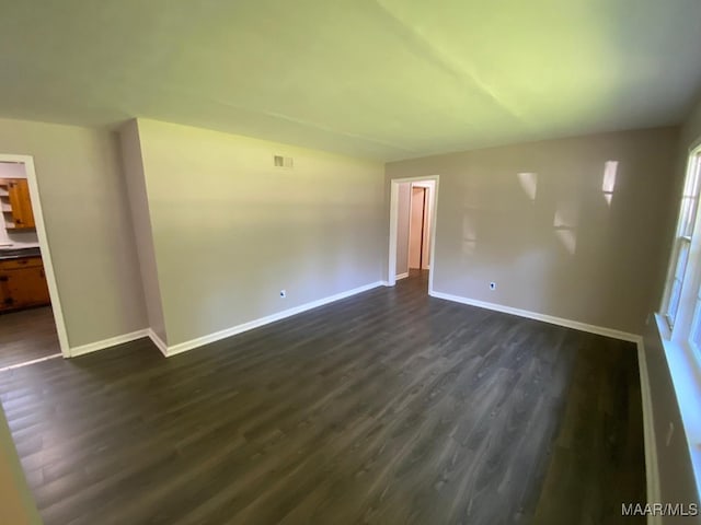 unfurnished room with dark wood-type flooring