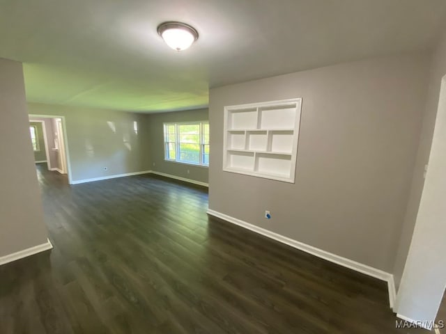 empty room with dark hardwood / wood-style flooring