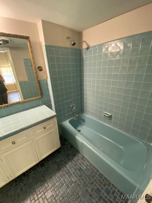 bathroom with tiled shower / bath and vanity