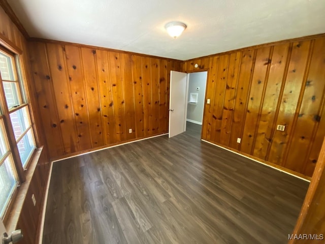 spare room with wood walls and dark wood-type flooring