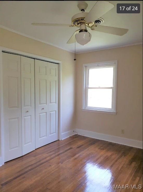 unfurnished bedroom featuring ornamental molding, a closet, ceiling fan, and dark hardwood / wood-style flooring