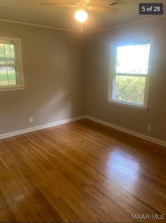 unfurnished room featuring a healthy amount of sunlight, ceiling fan, and hardwood / wood-style flooring