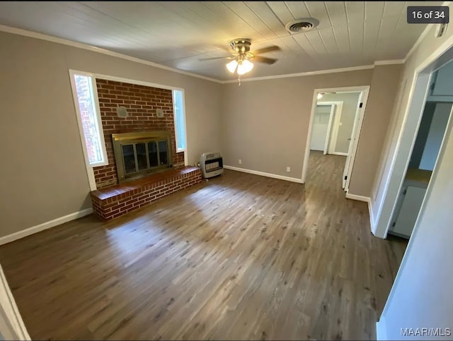 unfurnished living room with heating unit, dark wood-type flooring, ceiling fan, and a fireplace