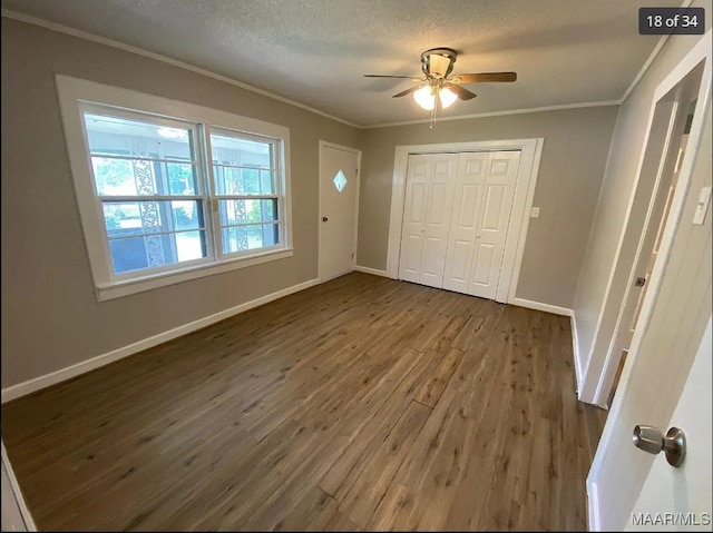 foyer entrance featuring a textured ceiling, crown molding, dark hardwood / wood-style floors, and ceiling fan