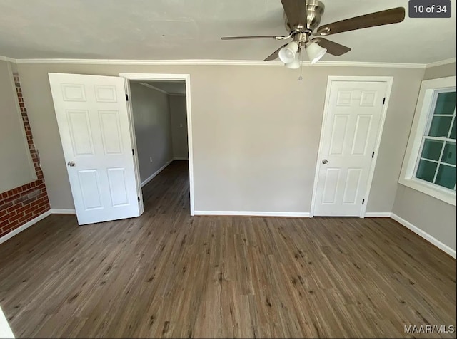 unfurnished bedroom featuring ornamental molding, ceiling fan, brick wall, and dark hardwood / wood-style floors