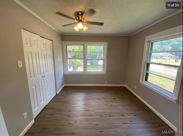 unfurnished bedroom featuring a textured ceiling, ceiling fan, dark hardwood / wood-style floors, and crown molding