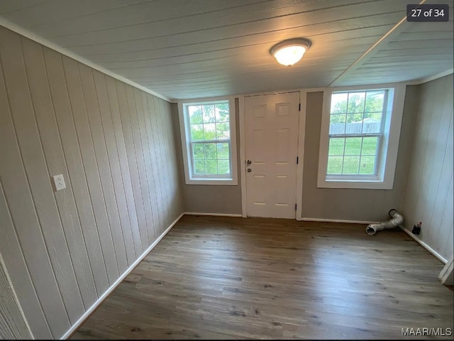 entrance foyer featuring wood-type flooring, wood ceiling, and wooden walls