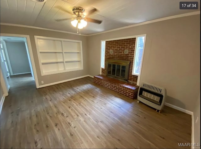 unfurnished living room featuring a brick fireplace, heating unit, ceiling fan, and hardwood / wood-style flooring