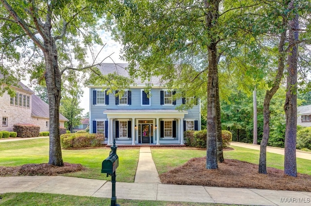 colonial-style house with a porch and a front lawn