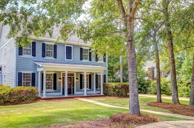 colonial house featuring covered porch and a front lawn