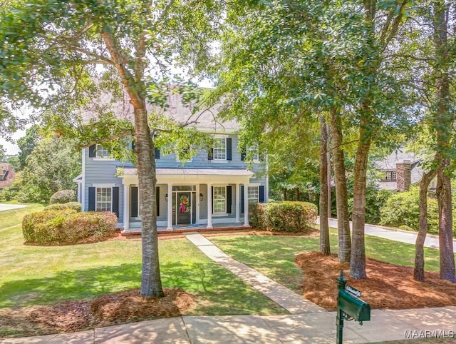 colonial home with a front yard and a porch