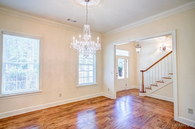 entryway with wood-type flooring, crown molding, and a healthy amount of sunlight