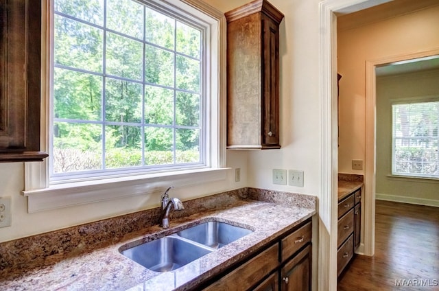 kitchen featuring light stone countertops, dark hardwood / wood-style floors, and sink