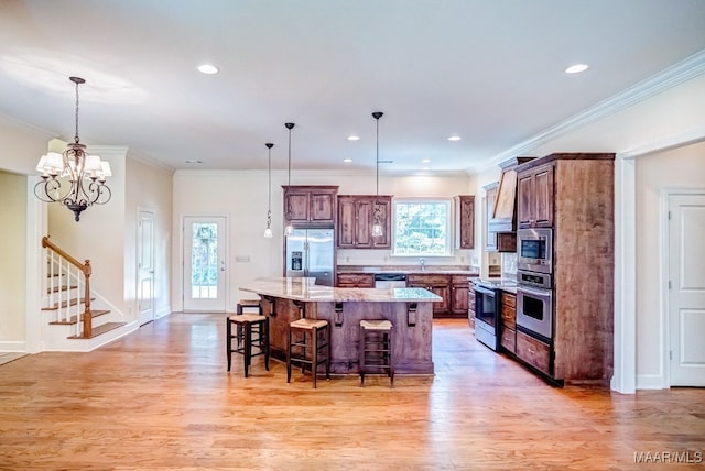 kitchen with a center island, plenty of natural light, stainless steel appliances, and light hardwood / wood-style flooring