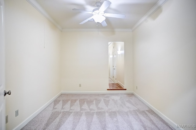 spare room featuring light carpet, ceiling fan, and crown molding