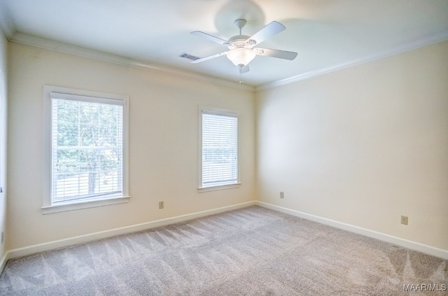 unfurnished room featuring ceiling fan, light colored carpet, and ornamental molding