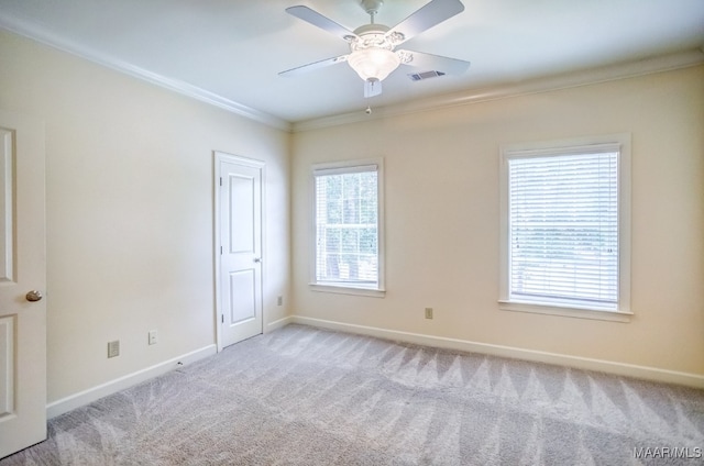 spare room with light carpet, ceiling fan, and crown molding