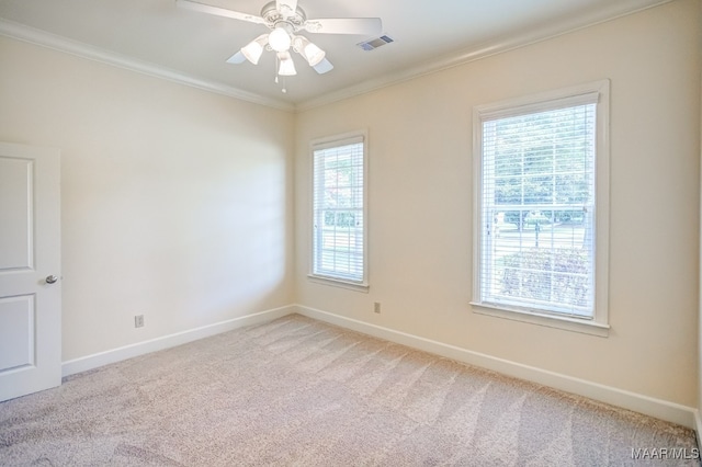 carpeted spare room with ceiling fan and crown molding