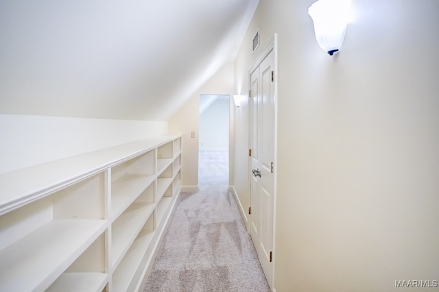 hall with light colored carpet and vaulted ceiling