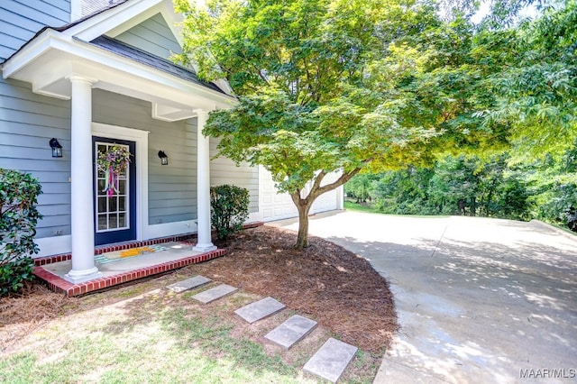 property entrance with a garage and covered porch