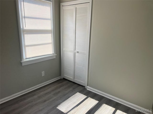 unfurnished bedroom featuring dark hardwood / wood-style flooring and a closet