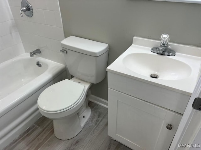 full bathroom with wood-type flooring, tiled shower / bath, vanity, and toilet