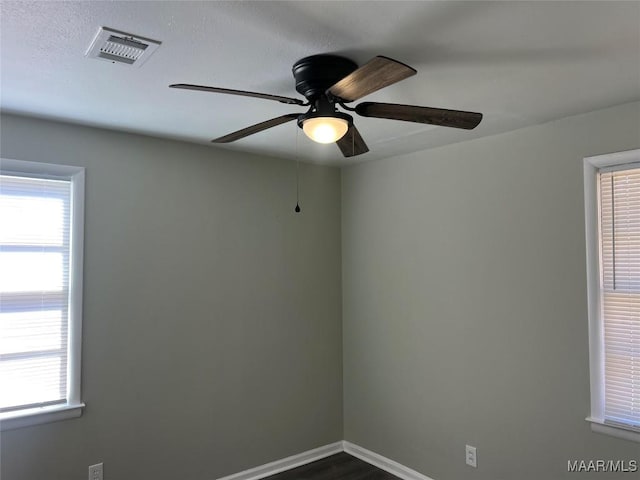 spare room featuring dark hardwood / wood-style flooring and ceiling fan