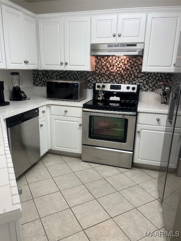 kitchen featuring appliances with stainless steel finishes, white cabinets, and tasteful backsplash