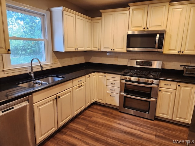 kitchen featuring dark wood-type flooring, backsplash, stainless steel appliances, and sink