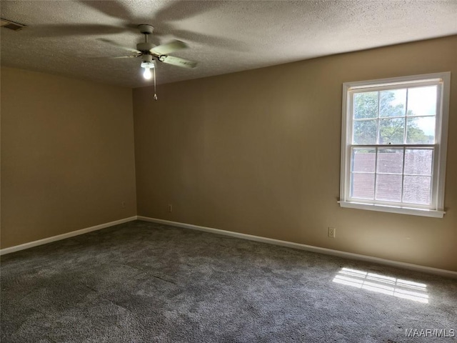 unfurnished room featuring baseboards, visible vents, ceiling fan, a textured ceiling, and dark carpet