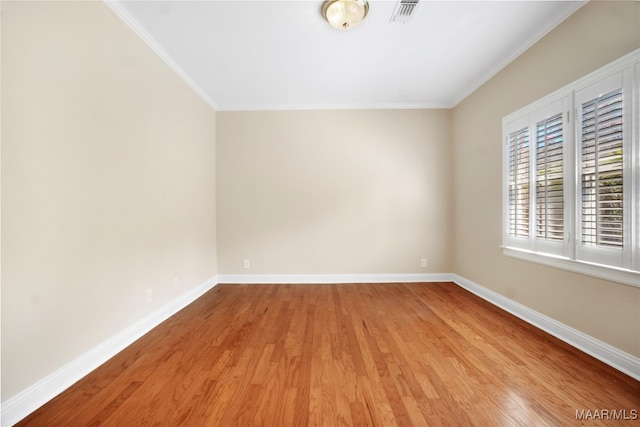 spare room featuring ornamental molding and hardwood / wood-style flooring