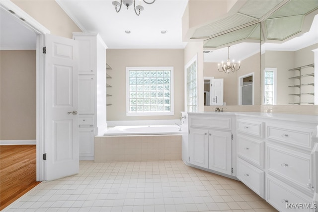 bathroom featuring vanity, an inviting chandelier, crown molding, tile patterned floors, and a relaxing tiled tub