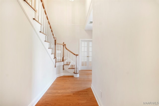 entrance foyer featuring a towering ceiling and light hardwood / wood-style flooring