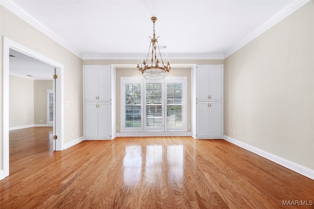 empty room with crown molding, light hardwood / wood-style flooring, and a notable chandelier