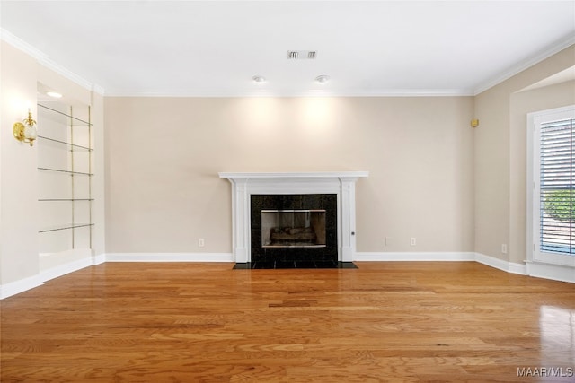 unfurnished living room with ornamental molding, hardwood / wood-style floors, and a tile fireplace