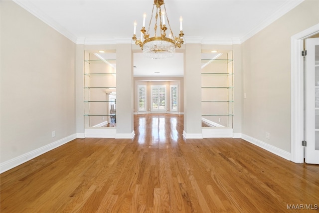 unfurnished dining area featuring ornamental molding, wood-type flooring, and a chandelier