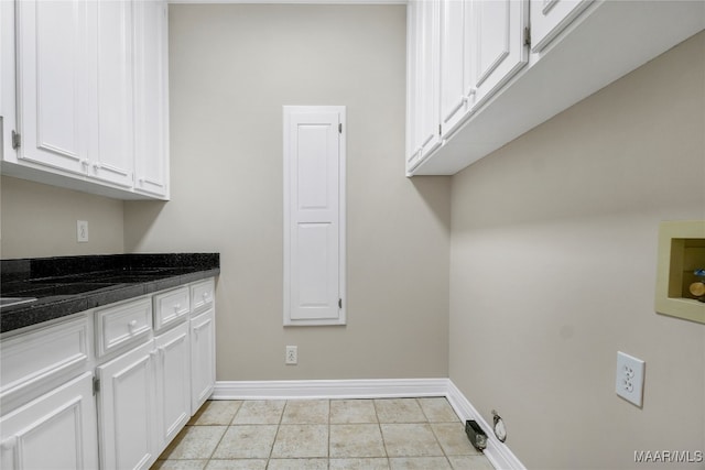 laundry area featuring hookup for a washing machine, light tile patterned floors, and cabinets