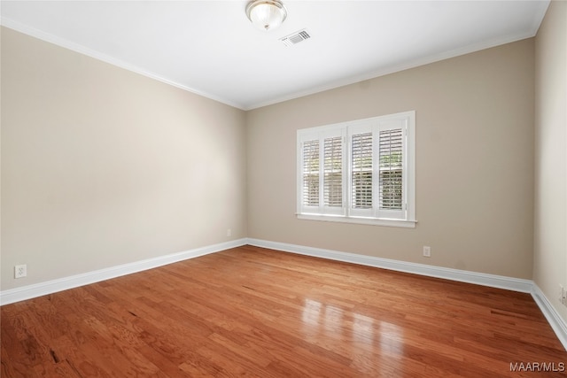 empty room featuring crown molding and light hardwood / wood-style floors