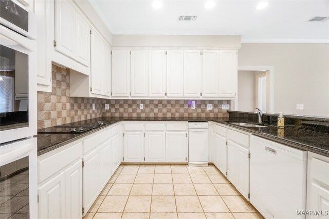 kitchen featuring dark stone countertops, white appliances, sink, and white cabinets