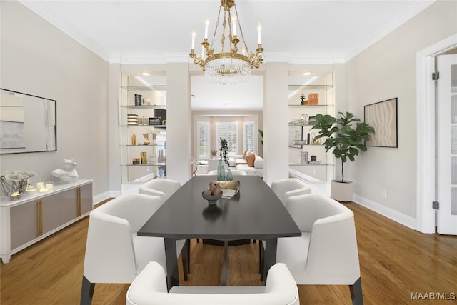 dining area with an inviting chandelier, ornamental molding, and hardwood / wood-style flooring