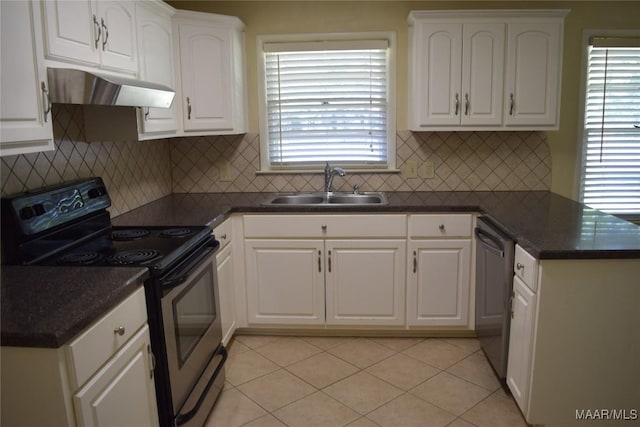 kitchen with dark countertops, a sink, appliances with stainless steel finishes, white cabinets, and under cabinet range hood