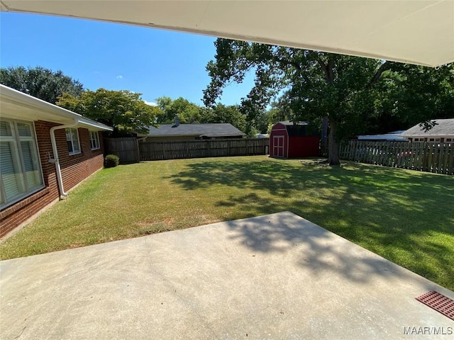 view of yard featuring an outdoor structure, a fenced backyard, a shed, and a patio