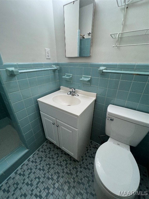 bathroom with backsplash, vanity, toilet, and tile walls