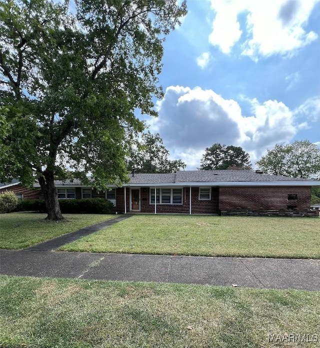 ranch-style home with a front lawn, brick siding, and an attached carport