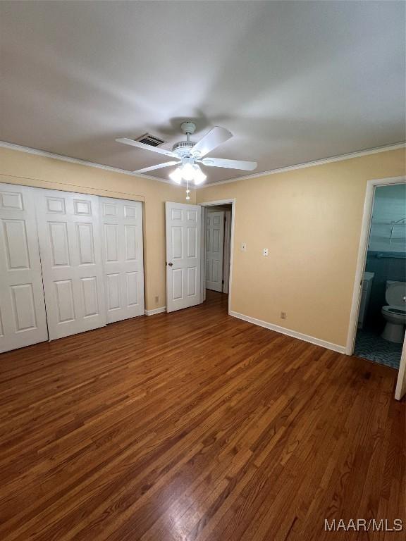 unfurnished bedroom with wood finished floors, a ceiling fan, a closet, crown molding, and baseboards