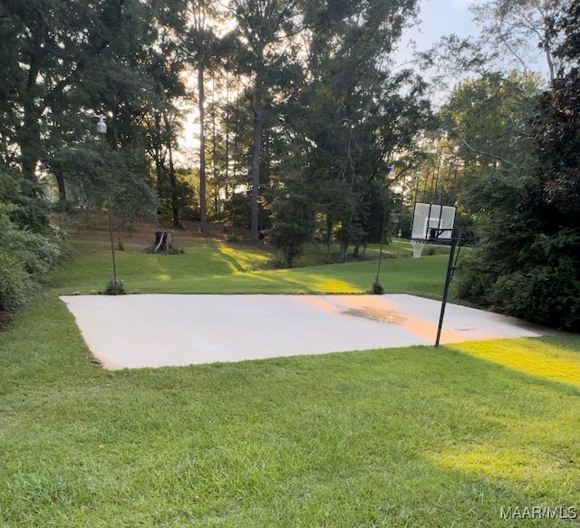 view of basketball court with a yard