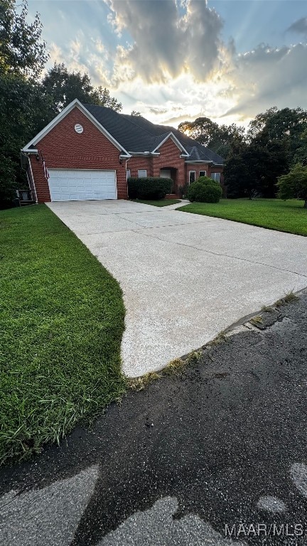 view of front of home with a yard and a garage