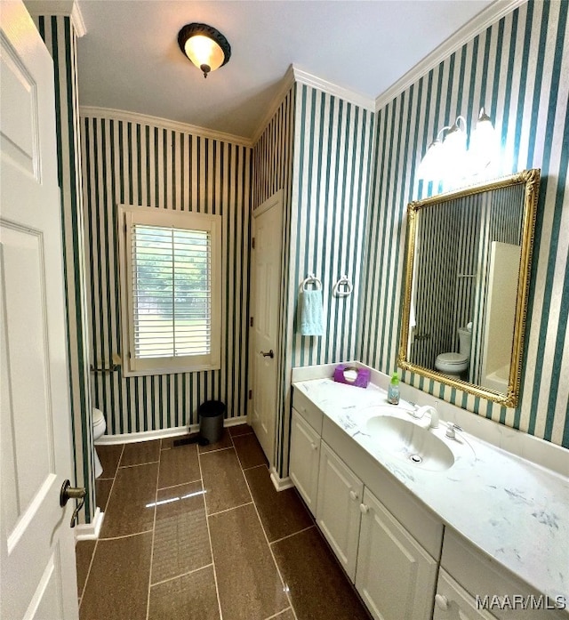 bathroom with ornamental molding, vanity, toilet, and tile patterned floors